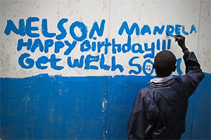 Ein Schuljunge in Nairobi malt zum 95. Geburtstag von Nelson Mandela seine Glückwünsche an eine Wand / Foto: EPA